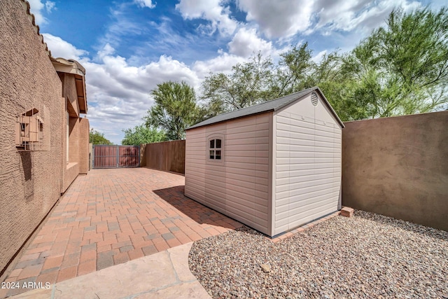 view of shed featuring a gate and fence