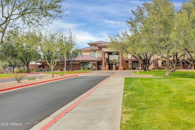 exterior space featuring a tiled roof, a front lawn, and stucco siding