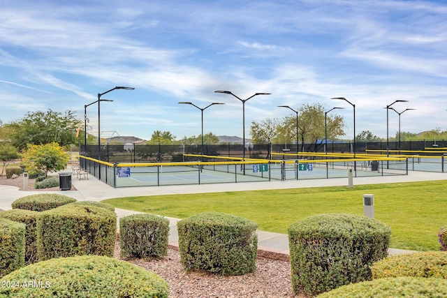 view of sport court featuring a yard and fence