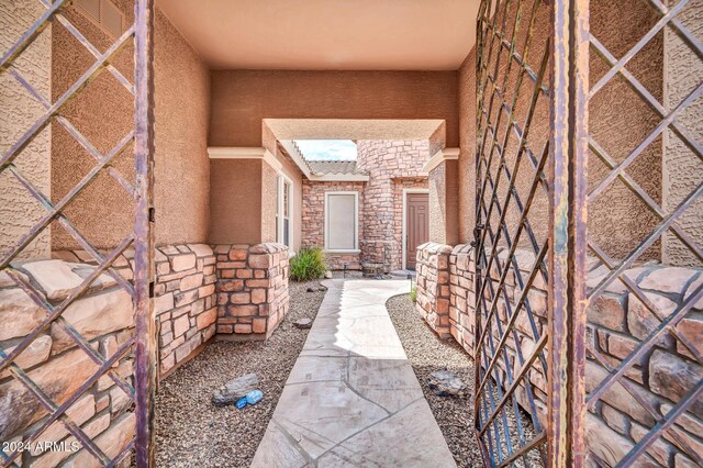 property entrance with stone siding and stucco siding