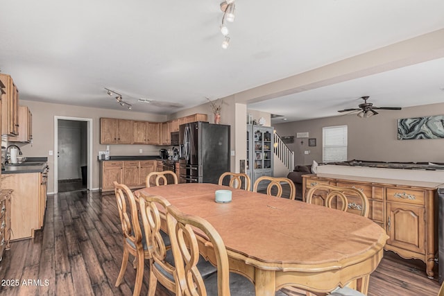 dining area with track lighting, dark wood-style flooring, ceiling fan, and stairway