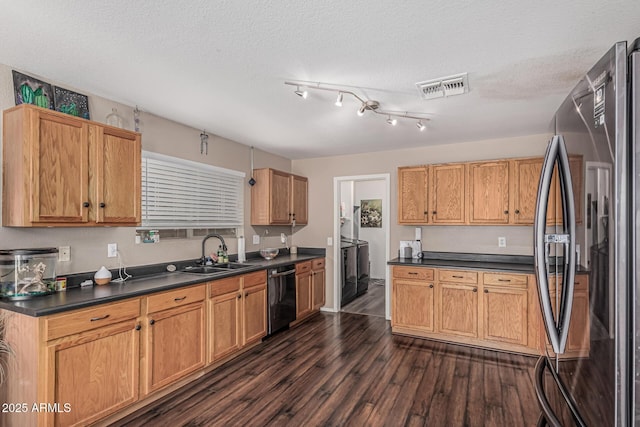kitchen featuring freestanding refrigerator, a sink, dishwasher, dark countertops, and dark wood-style flooring