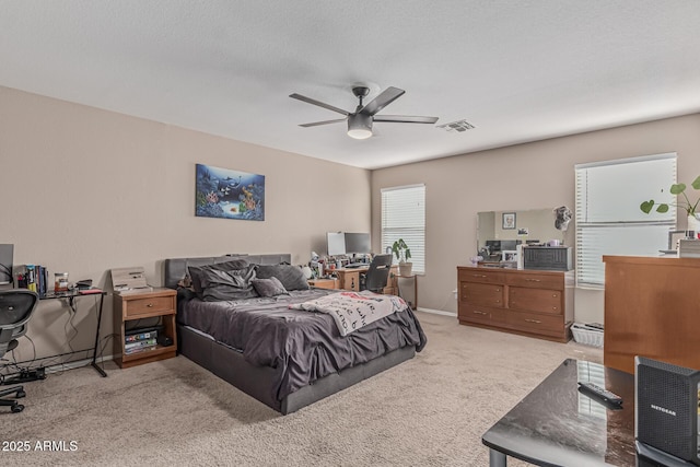 bedroom featuring carpet, an office area, and a ceiling fan