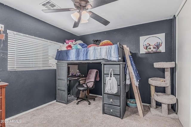 carpeted bedroom with a textured wall, ceiling fan, baseboards, and a desk
