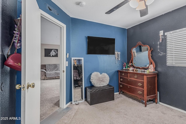 carpeted bedroom featuring a textured wall, ceiling fan, and baseboards