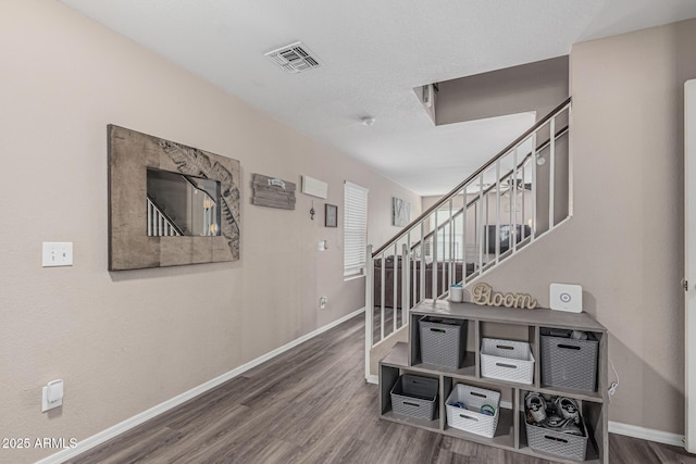 staircase featuring baseboards and wood finished floors