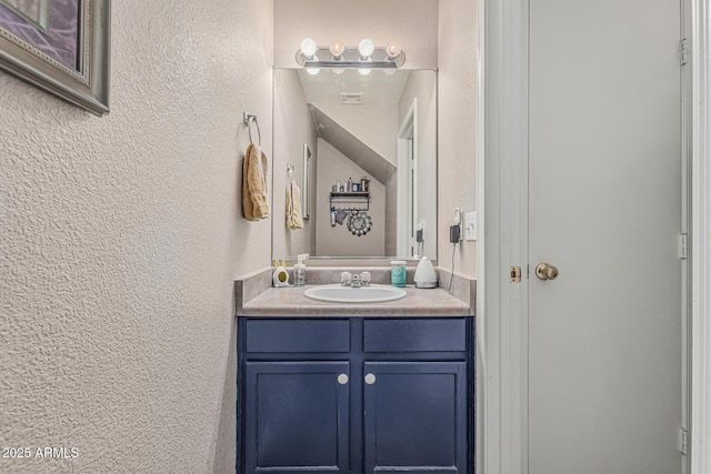 bathroom featuring a textured wall and vanity