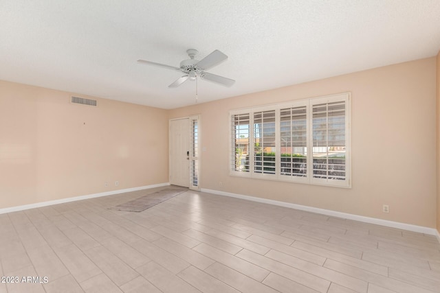 unfurnished room with ceiling fan, light hardwood / wood-style floors, and a textured ceiling