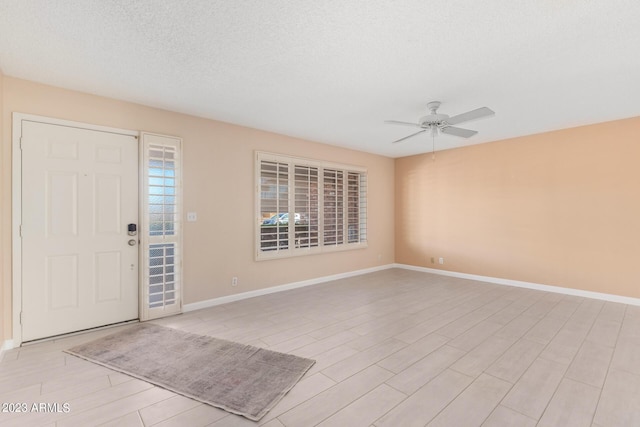 entrance foyer featuring ceiling fan and a textured ceiling