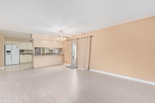 unfurnished living room with a textured ceiling and ceiling fan