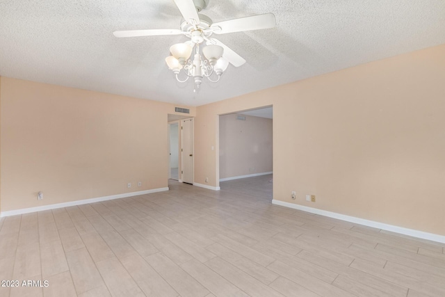 empty room featuring ceiling fan, light hardwood / wood-style floors, and a textured ceiling