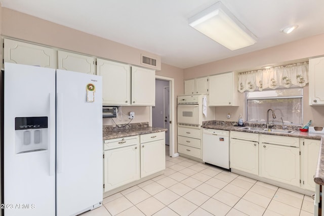 kitchen featuring light tile patterned floors, white appliances, white cabinetry, and sink