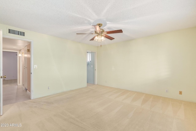 empty room with light carpet, a textured ceiling, and ceiling fan