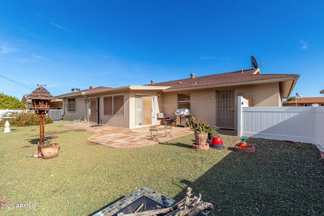 rear view of property with central AC unit, a yard, and a patio