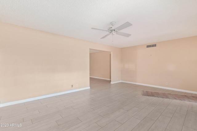 unfurnished room featuring ceiling fan, light hardwood / wood-style flooring, and a textured ceiling