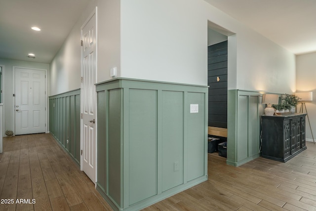 corridor featuring recessed lighting, wainscoting, and wood finished floors