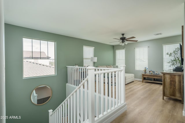 interior space with visible vents, multiple windows, light wood-style floors, and baseboards