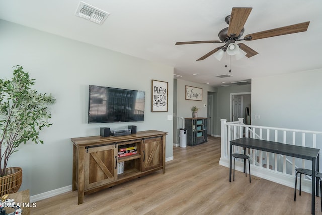 interior space featuring baseboards, light wood-style floors, visible vents, and ceiling fan