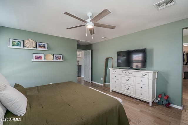 bedroom with visible vents, baseboards, ceiling fan, and wood finished floors