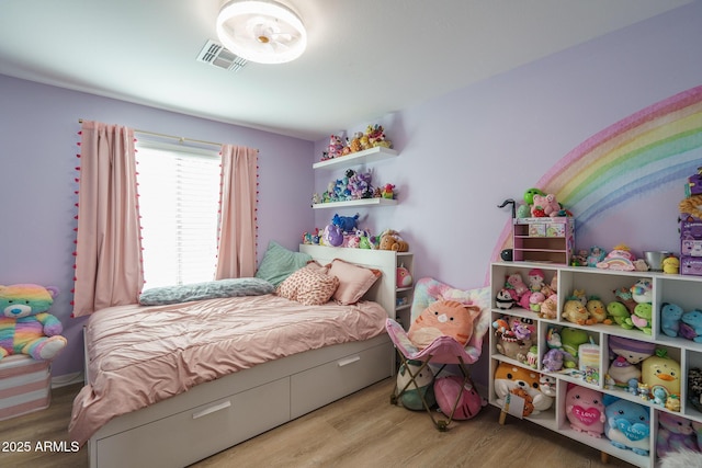 bedroom featuring wood finished floors and visible vents