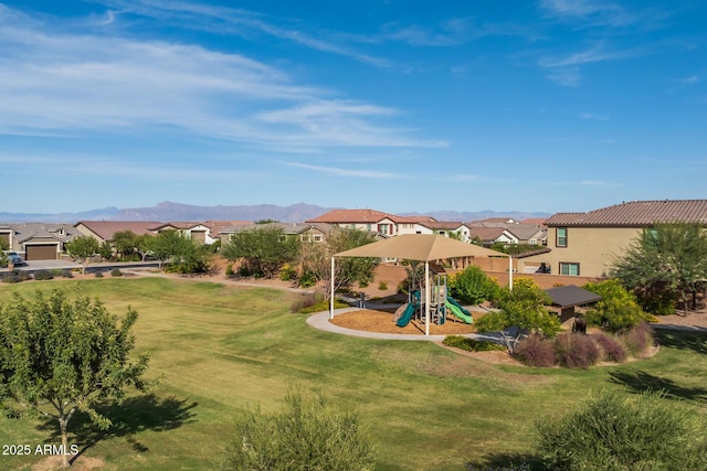 exterior space featuring a mountain view, a yard, and a residential view