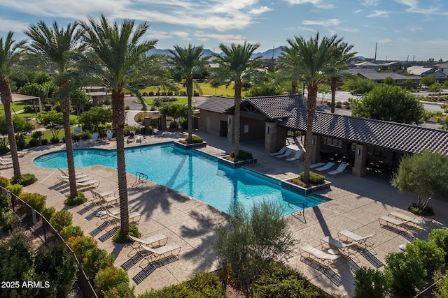 pool with a patio area and fence