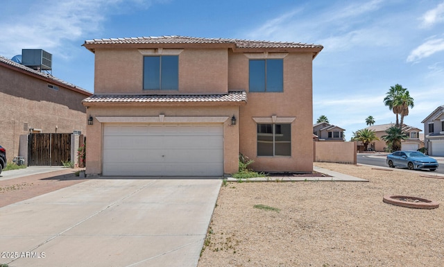view of front of home with stucco siding, an attached garage, driveway, and a tiled roof