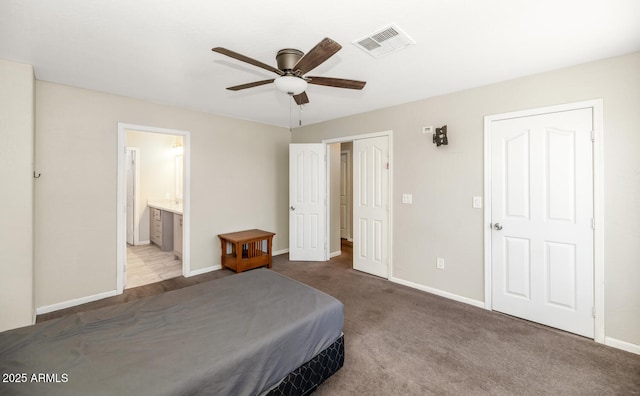 bedroom with baseboards, ensuite bathroom, a ceiling fan, and carpet flooring