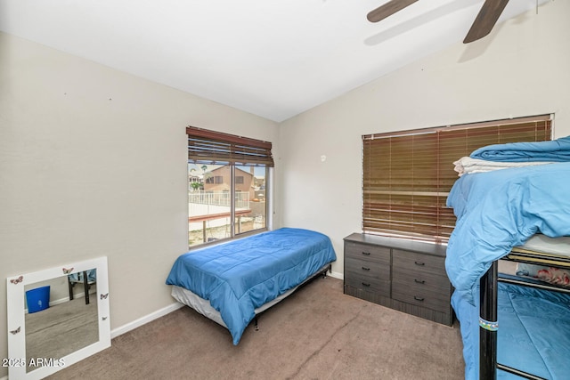 bedroom with vaulted ceiling, carpet, baseboards, and ceiling fan
