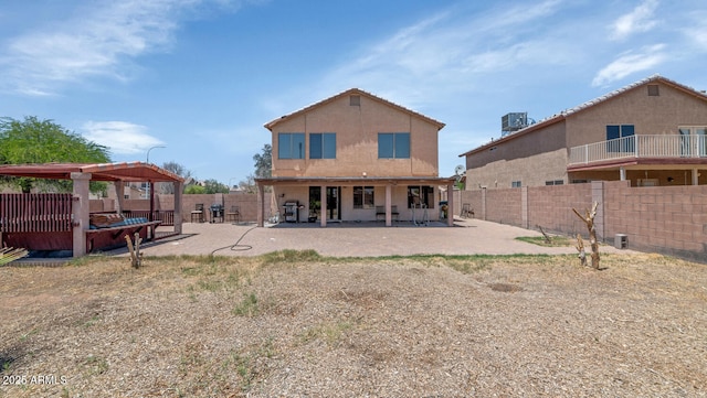 rear view of property featuring a fenced backyard, a patio area, and a gazebo