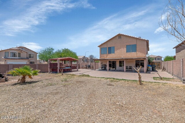 back of property with a gazebo, a fenced backyard, a patio, a jacuzzi, and stucco siding