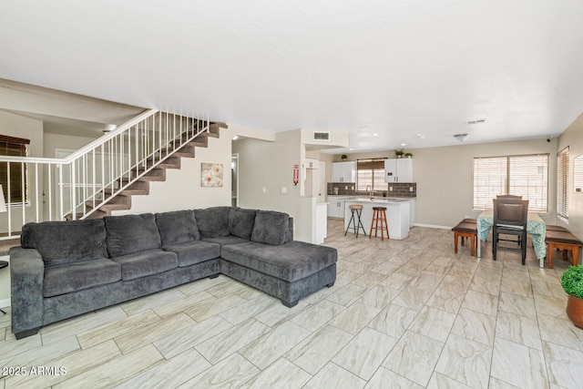 living area with stairs and light marble finish flooring