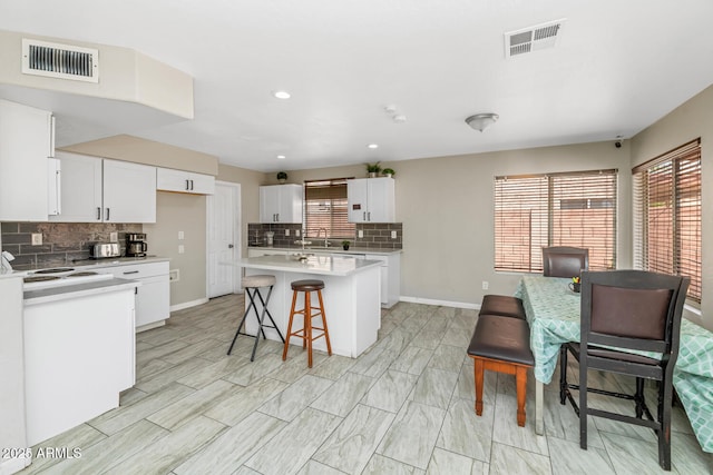 kitchen featuring decorative backsplash, plenty of natural light, a breakfast bar, and recessed lighting