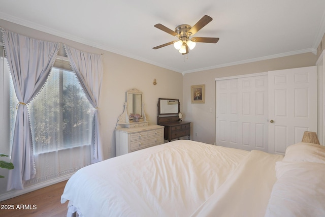 bedroom with hardwood / wood-style floors, a closet, ceiling fan, and crown molding