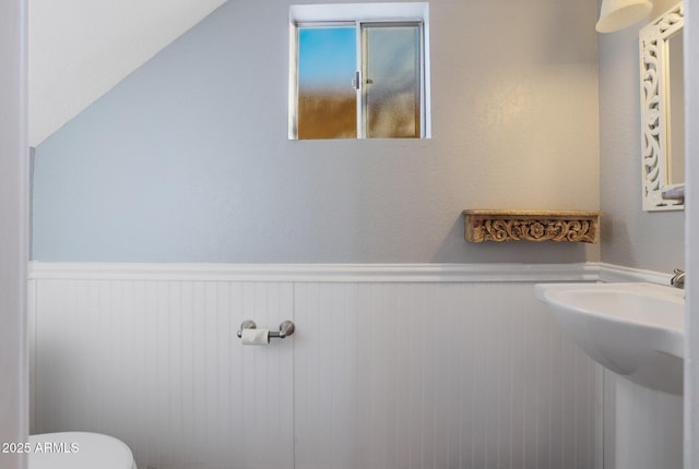 bathroom featuring sink, vaulted ceiling, and toilet