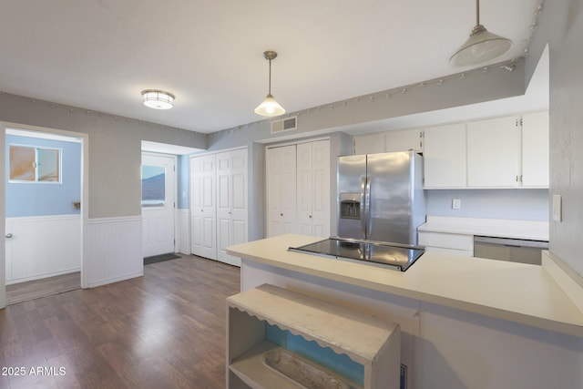 kitchen featuring dark hardwood / wood-style floors, stainless steel fridge, pendant lighting, dishwashing machine, and black electric stovetop