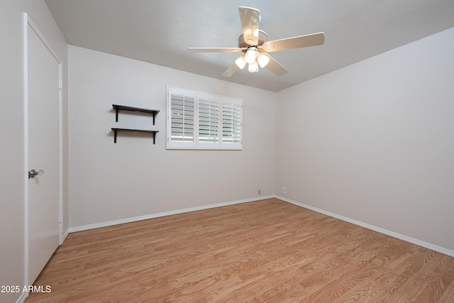 unfurnished room with wood finished floors, a ceiling fan, and baseboards