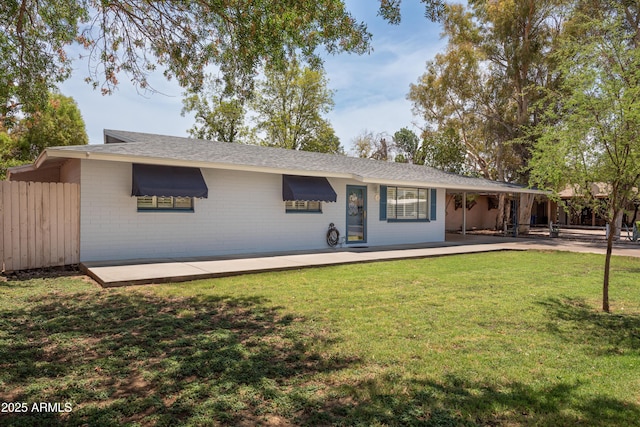 ranch-style house featuring brick siding, a front yard, and fence