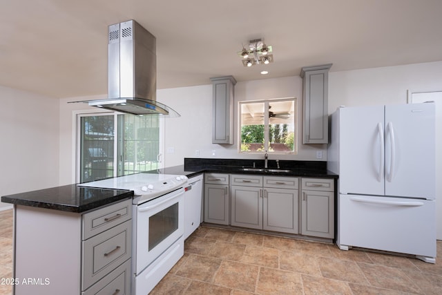 kitchen featuring island range hood, a peninsula, white appliances, a sink, and gray cabinets