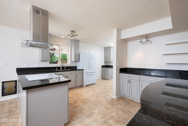 kitchen featuring island range hood, freestanding refrigerator, a peninsula, stovetop, and open shelves