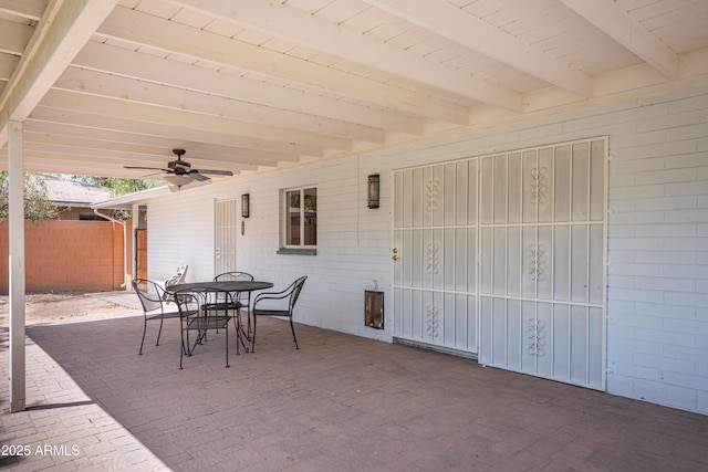 view of patio featuring outdoor dining space, fence, and a ceiling fan