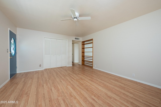 unfurnished bedroom with a closet, visible vents, light wood-style floors, ceiling fan, and baseboards