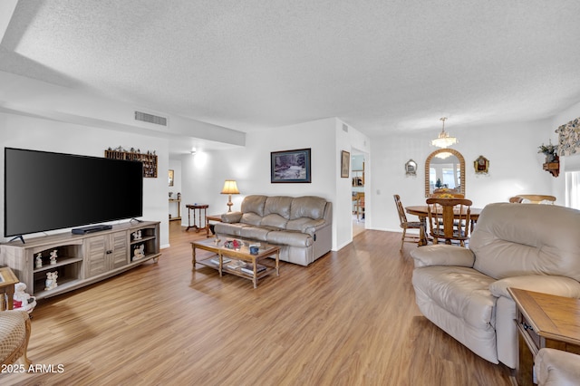 living room with a textured ceiling and light hardwood / wood-style floors