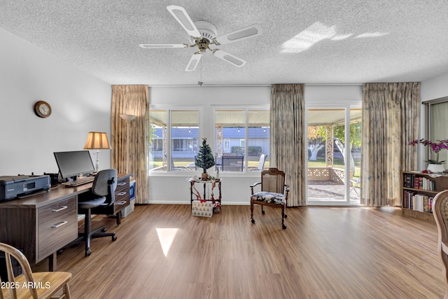 office with a textured ceiling, ceiling fan, and light hardwood / wood-style floors