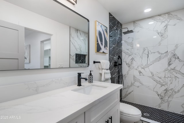 bathroom featuring vanity, toilet, and tiled shower