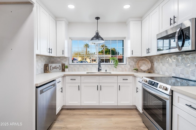 kitchen with white cabinetry, sink, backsplash, and stainless steel appliances