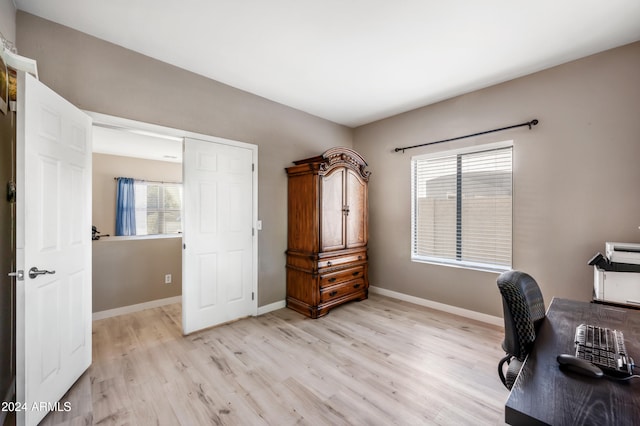 home office with a healthy amount of sunlight and light hardwood / wood-style floors