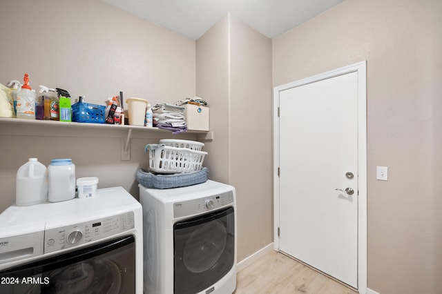 laundry room with independent washer and dryer and light hardwood / wood-style flooring