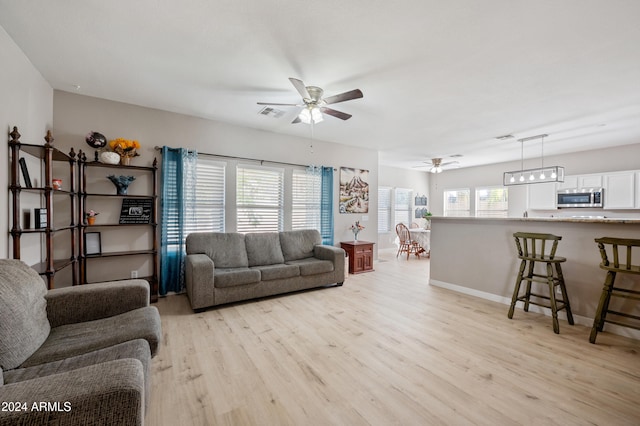 living room with ceiling fan and light wood-type flooring