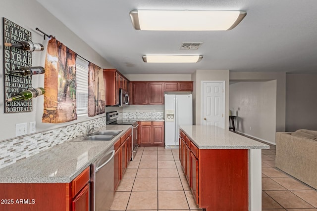 681 W Racine Loop, Casa Grande, AZ 85122 - kitchen featuring appliances with stainless steel finishes, a sink, light tile patterned flooring, open floor plan, and a kitchen island
